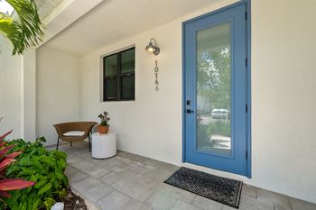 The front porch of a house with a blue door